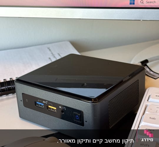 מחשב קטן על שולחן ליד מקלדת ועכבר